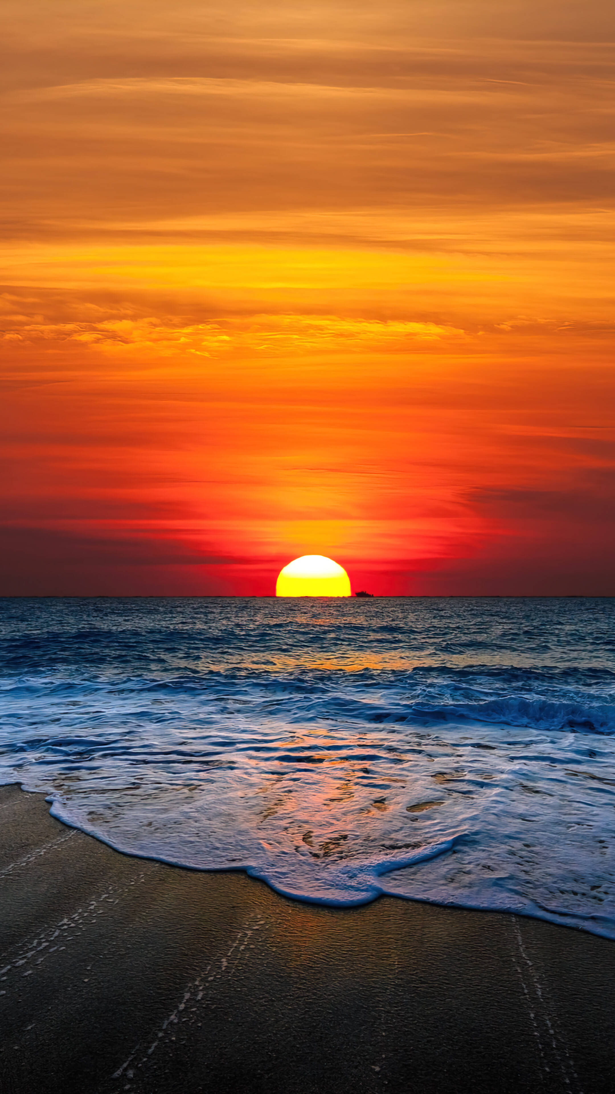沙灘上的橘色日落 Android 壁紙
