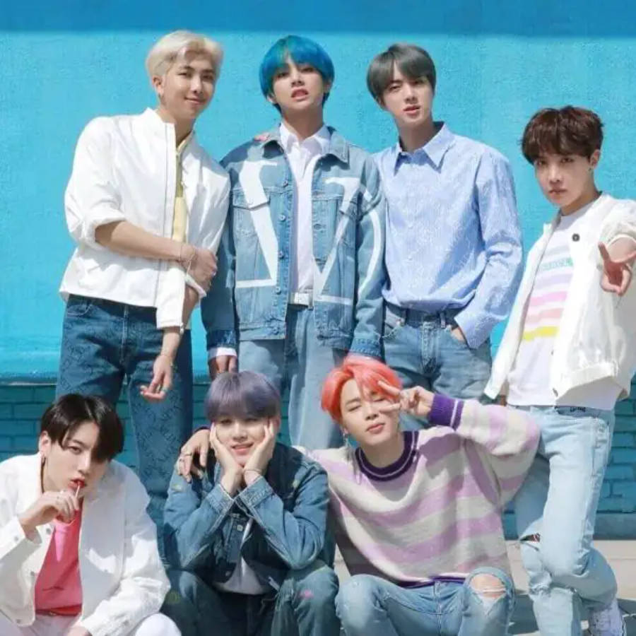 可愛的BTS團體在藍色牆前擺姿勢 壁紙