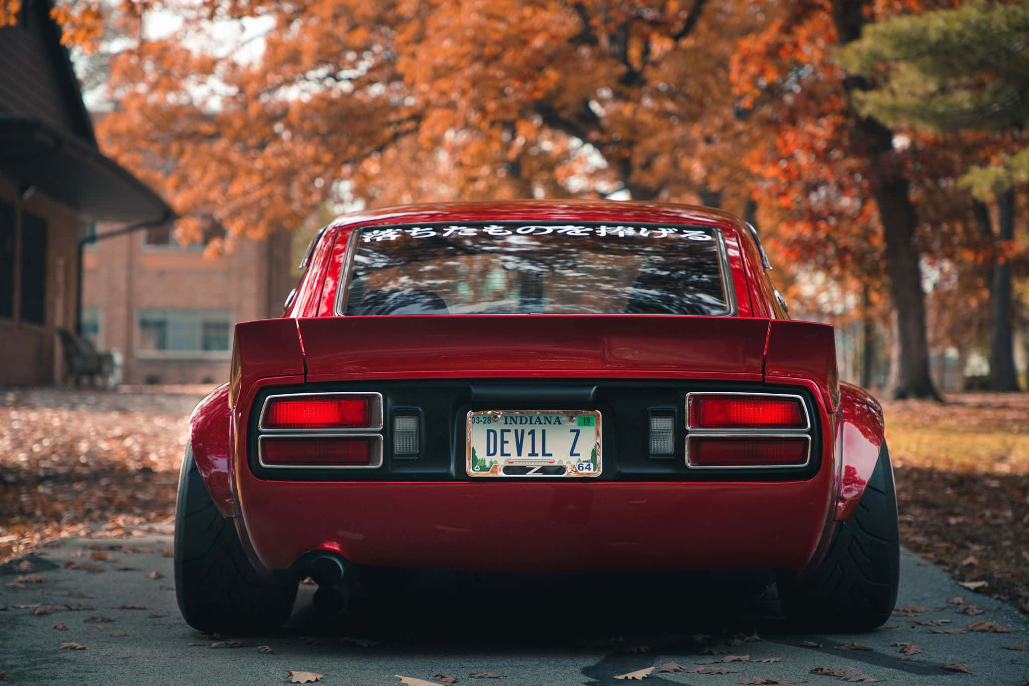 停放於城市街道的紅色Datsun 壁紙