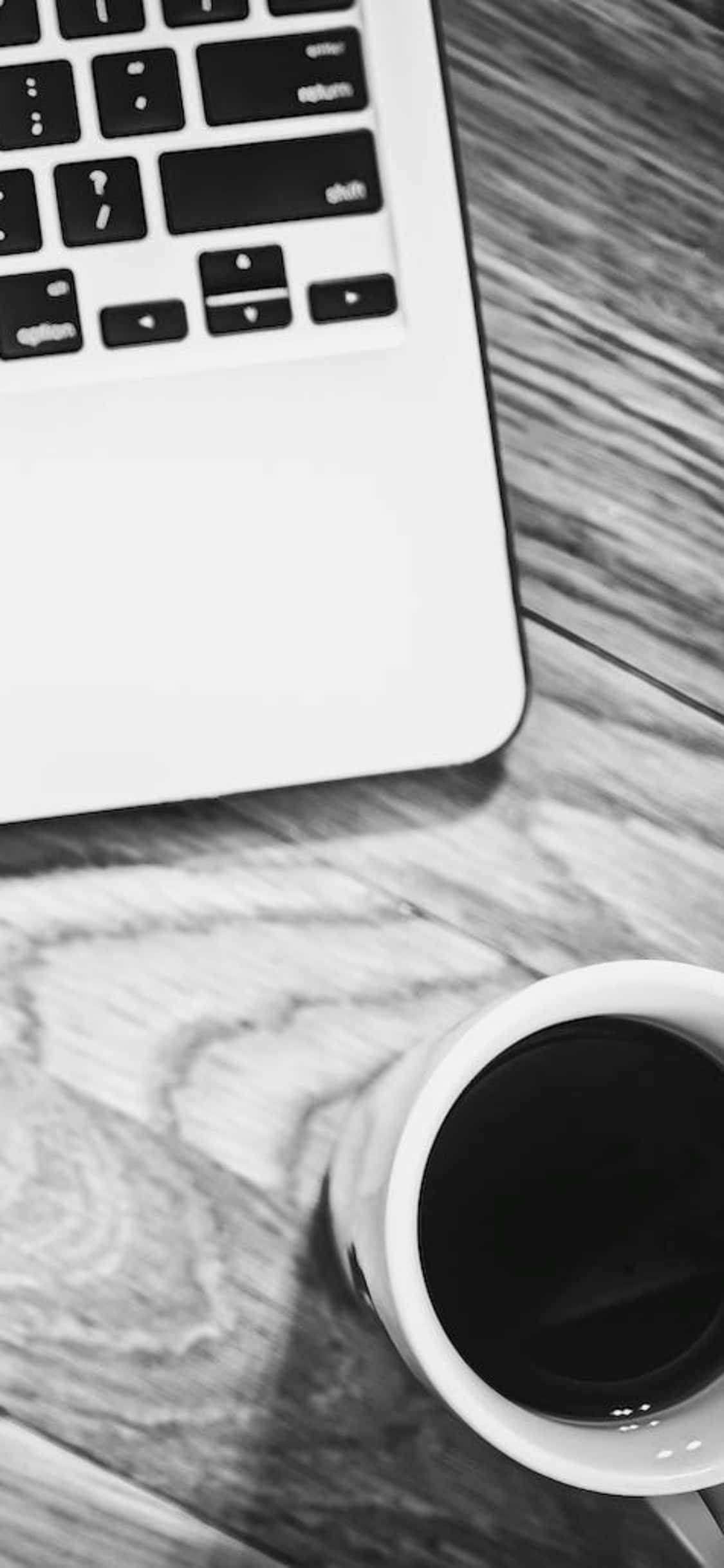 iPhone X 桌面黑白照片背景，附杯子與筆記型電腦 壁紙