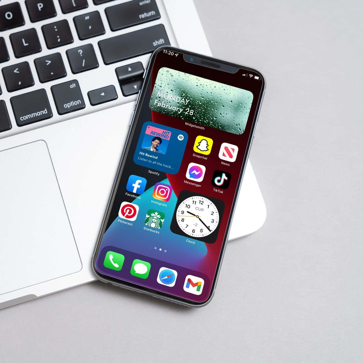iPhone XR 与笔记本电脑并排摆放，屏幕上显示应用图标 壁紙