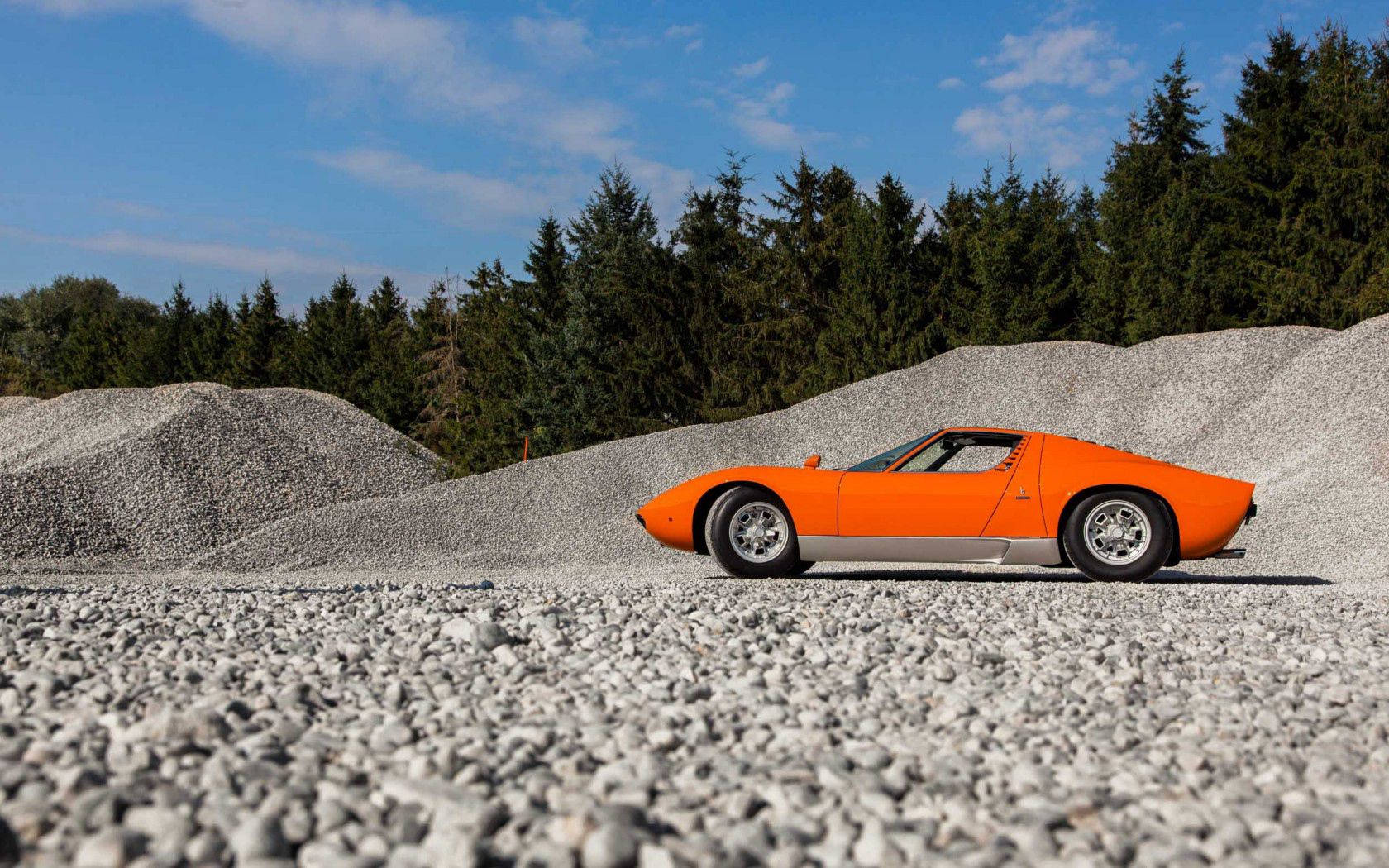 碎石路上的精緻橘色藍寶堅尼 Miura 壁紙