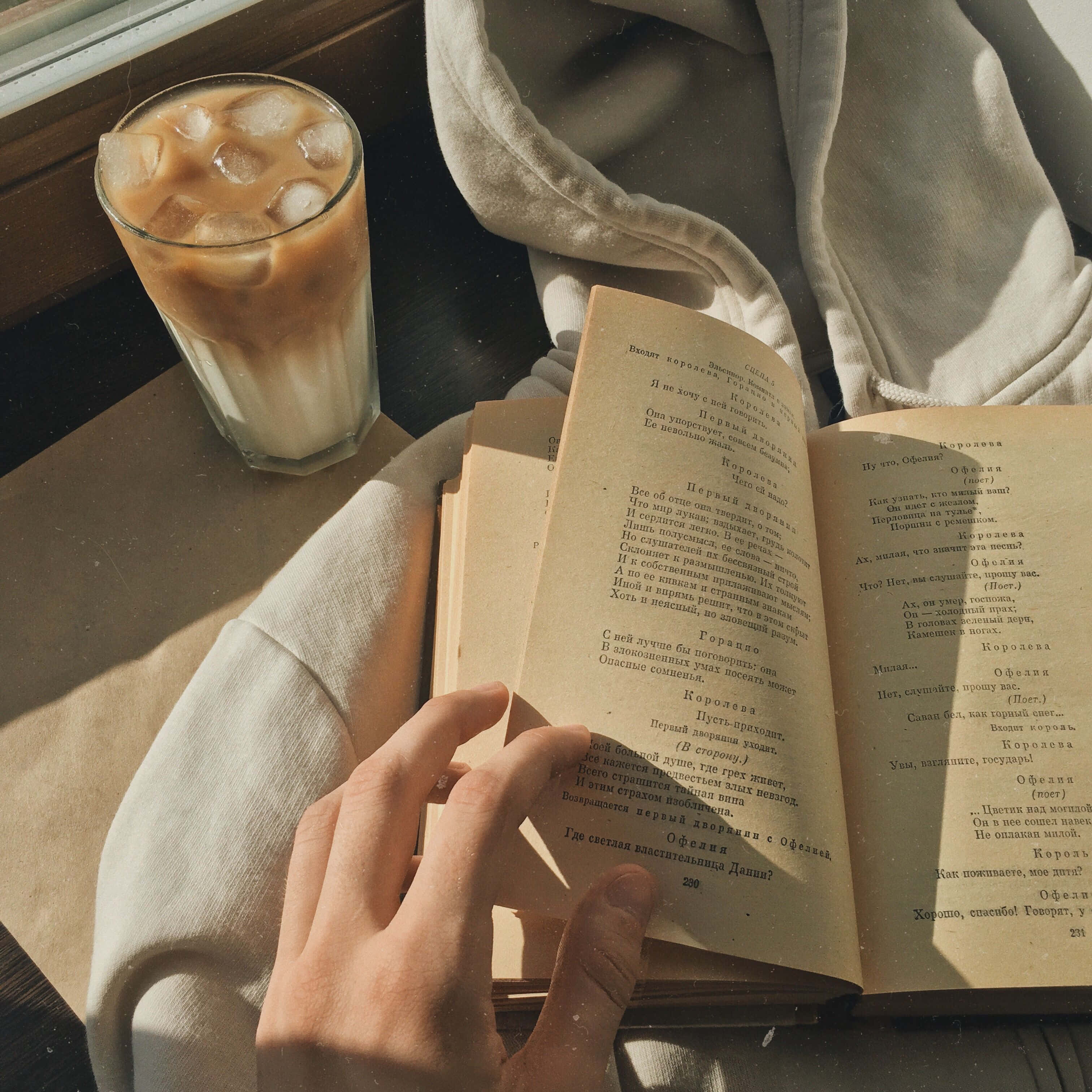 一個人正在看書，旁邊放著一杯咖啡 壁紙