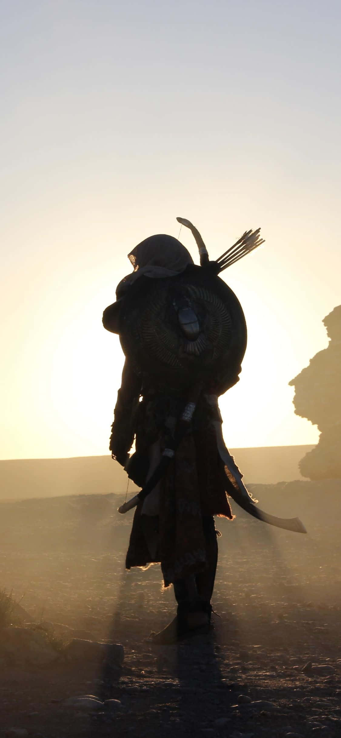 一名身穿袍子的男子在沙漠中行走 壁紙