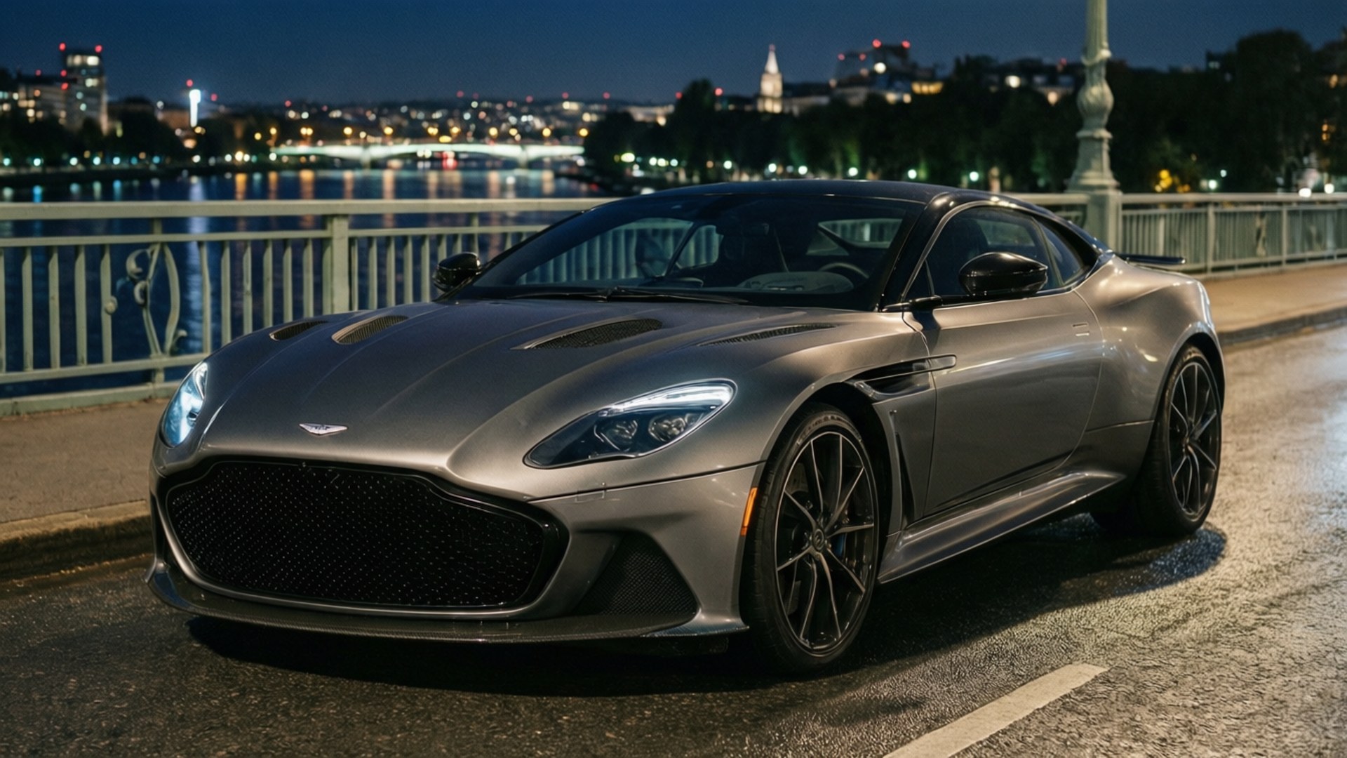 夜間橋上的Aston Martin DBS Superleggera，伴隨城市燈光。