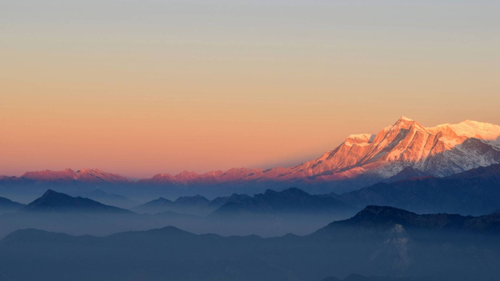 夕陽時分覆雪山脈的景象 壁紙