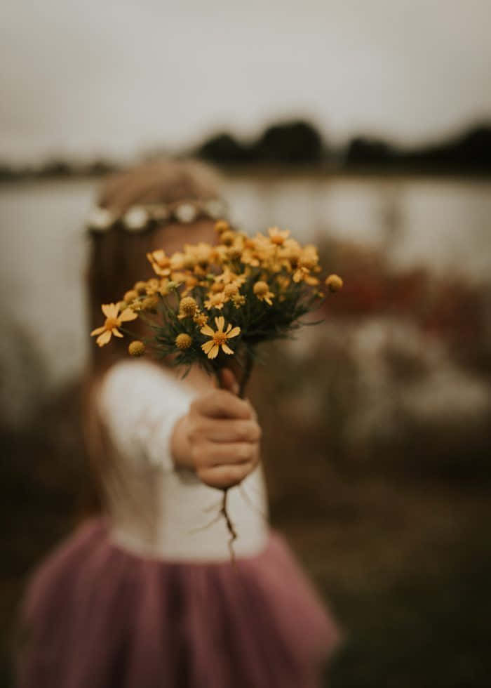 情感女孩手持黃色花朵照片 壁紙