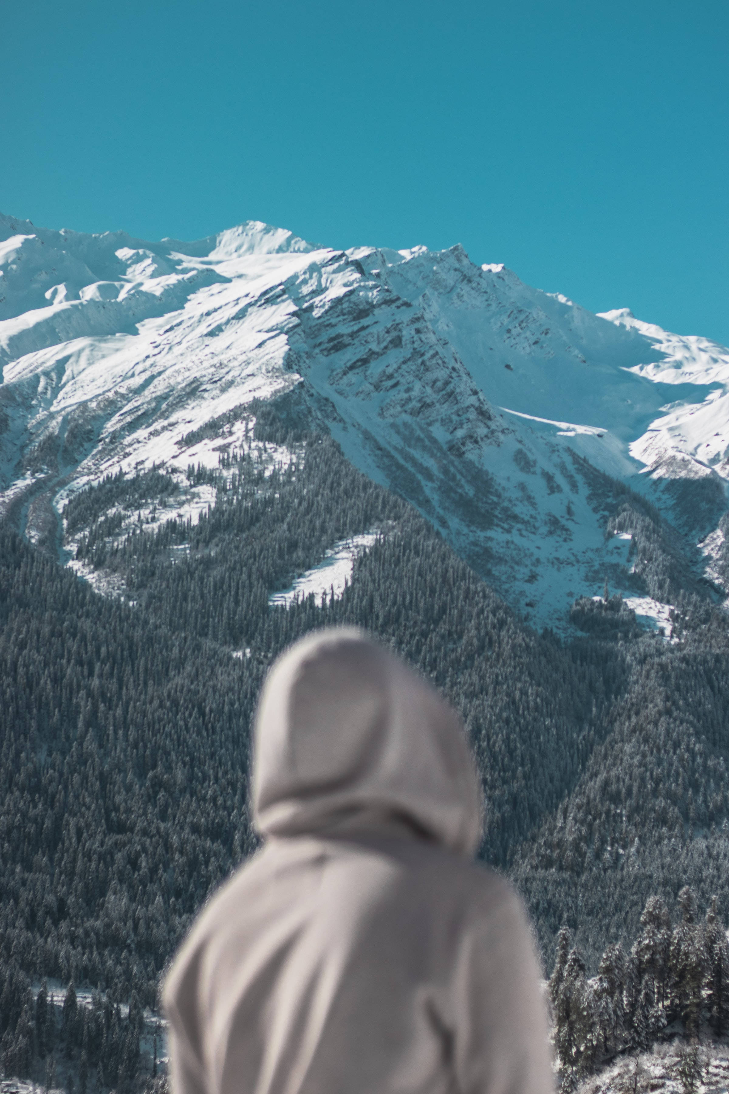 戴兜帽的人影侧对雪山 壁紙