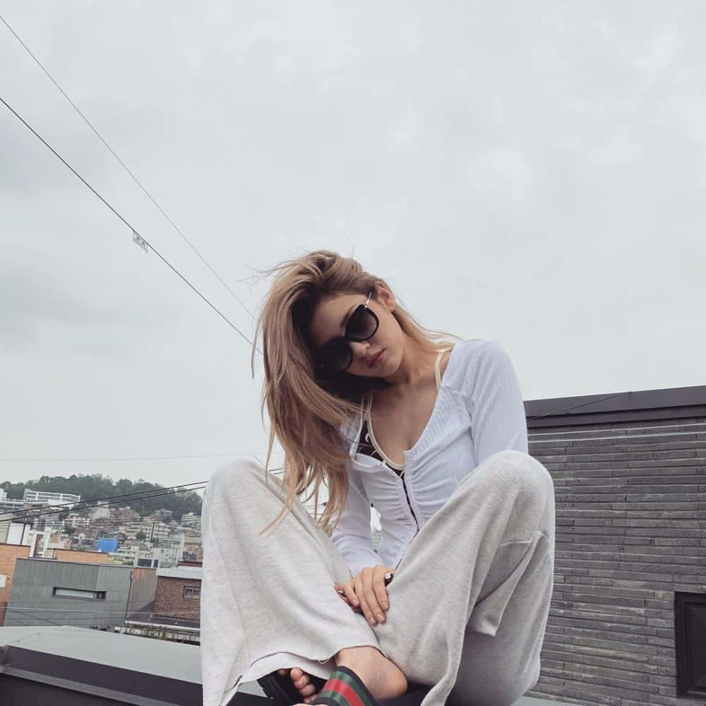 戴著太陽眼鏡坐在屋頂上的女子 壁紙
