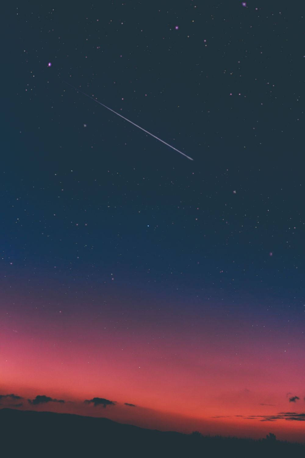 粉紅深色夜空中有流星與美學天空。戲劇性而奇幻的天空與星辰，帶著粉藍色調。