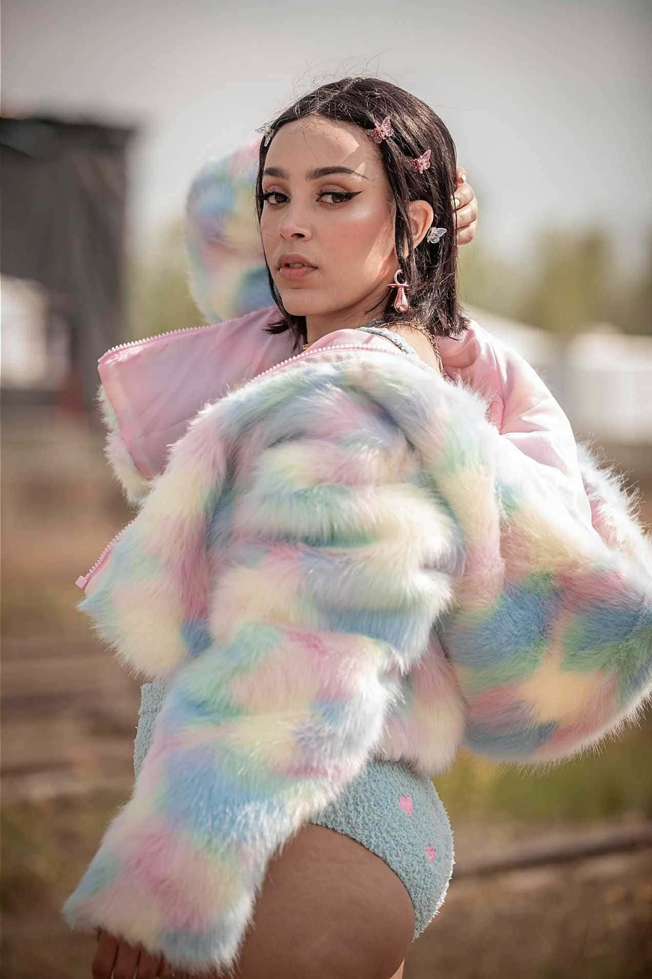 穿著彩色皮草外套擺姿勢的女性 壁紙