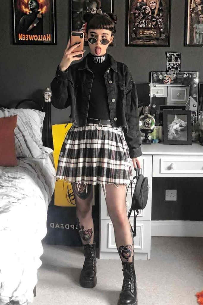 穿著格子裙與黑色外套的女孩正在自拍 壁紙