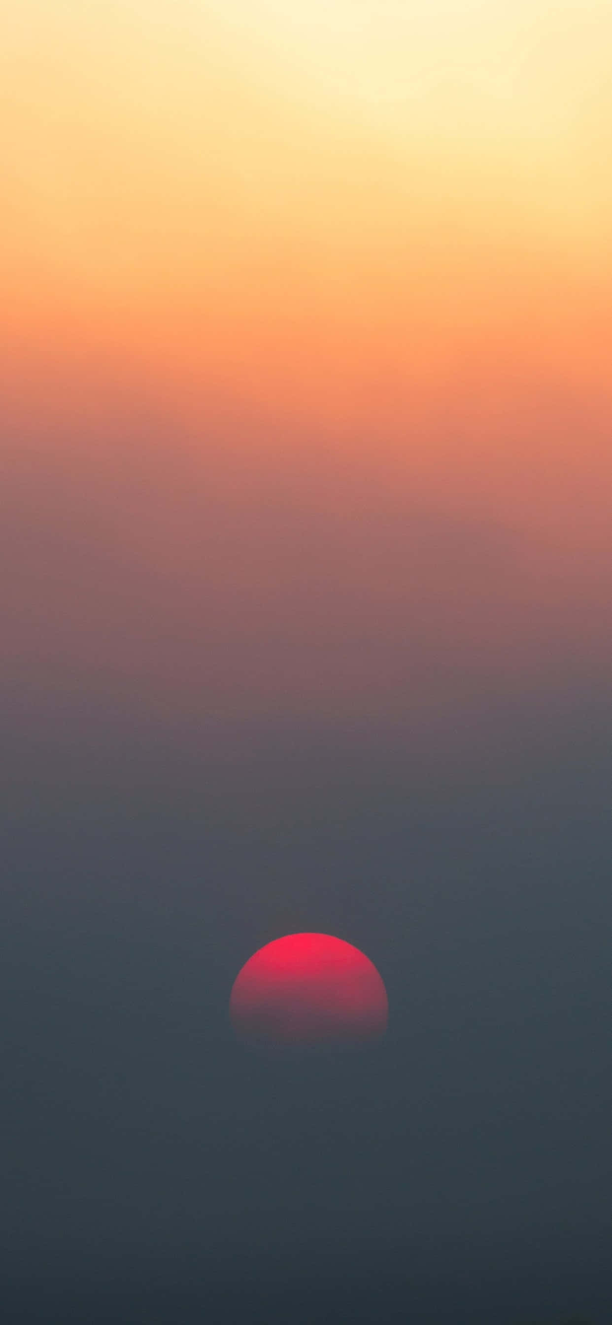 雾霭天空中升起的一轮红日 壁紙