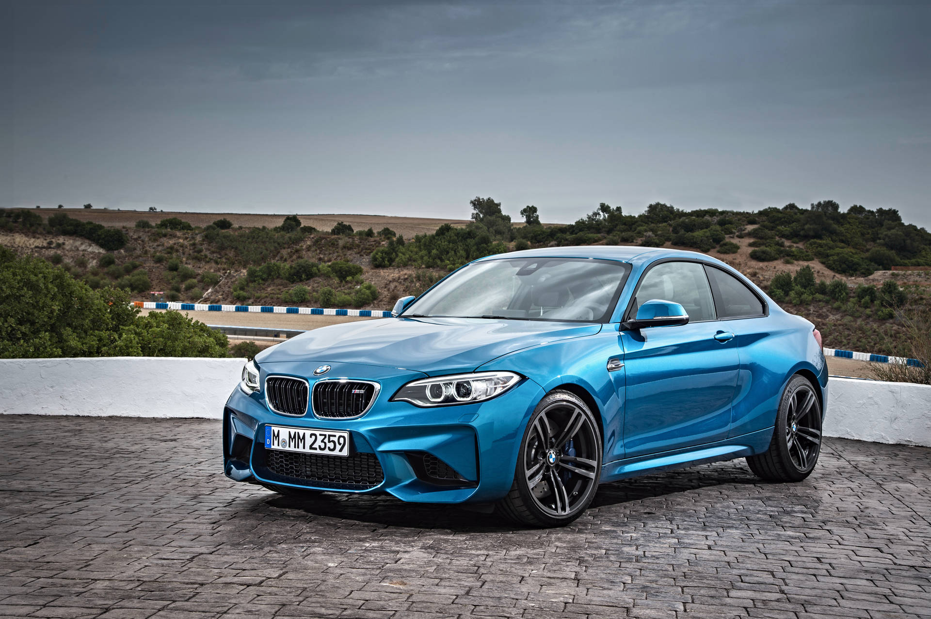 藍色BMW F87行駛於路面，遠眺山景的桌布 — 宝马 壁紙