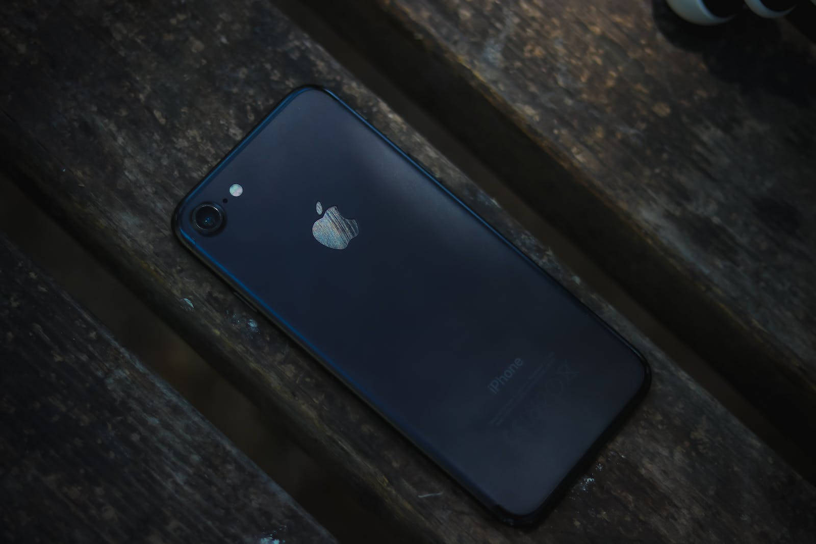 黑色iPhone 7置于木质桌面 壁紙