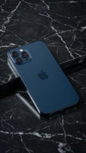 午夜藍色iPhone 17置於大理石上，極簡風格攝影棚拍攝。