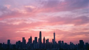 粉紫色夕陽映襯著城市摩天大樓的剪影。 — 天空景观 壁紙