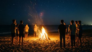 青少年在海浪海灘上圍著篝火聚集。