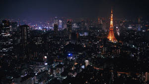 東京鐵塔在夜晚城市中的空拍桌布