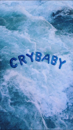 酷炫藍色美學桌布，巨大的氣球字母「Crybaby」漂浮在藍色海洋或海面上。