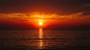 对称的海上日落，映出橙红相间的倒影。 — 天空景观 壁紙