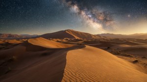 沙漠沙丘上空的星空，银河系清晰可见。