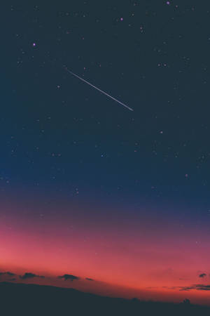 粉紅深色夜空中有流星與美學天空。戲劇性而奇幻的天空與星辰，帶著粉藍色調。