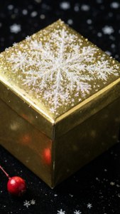 黑色表面上带有雪花和浆果的闪亮金色礼物。 — iPhone 7 壁紙
