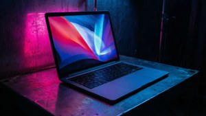 赛博朋克风格的MacBook，在暗室中映出霓虹光影。